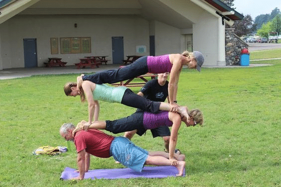 Four people are doing arco yoga